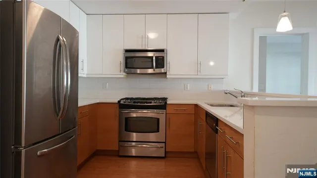 a kitchen with stainless steel appliances granite countertop a refrigerator stove and sink