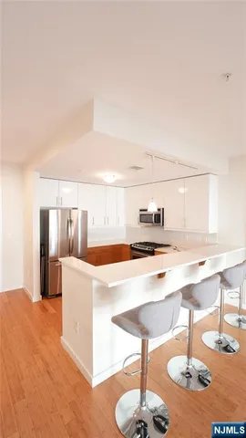 a kitchen with kitchen island stainless steel appliances a sink and cabinets