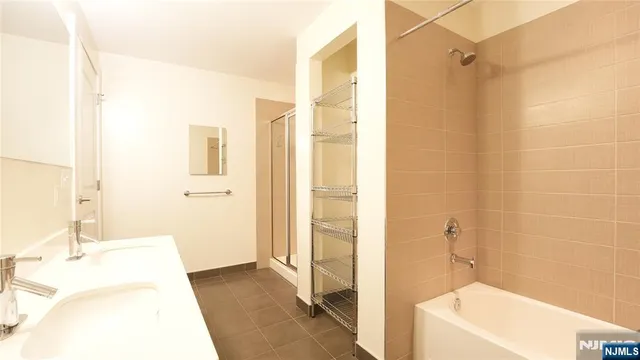 a bathroom with a tub a sink and a shower