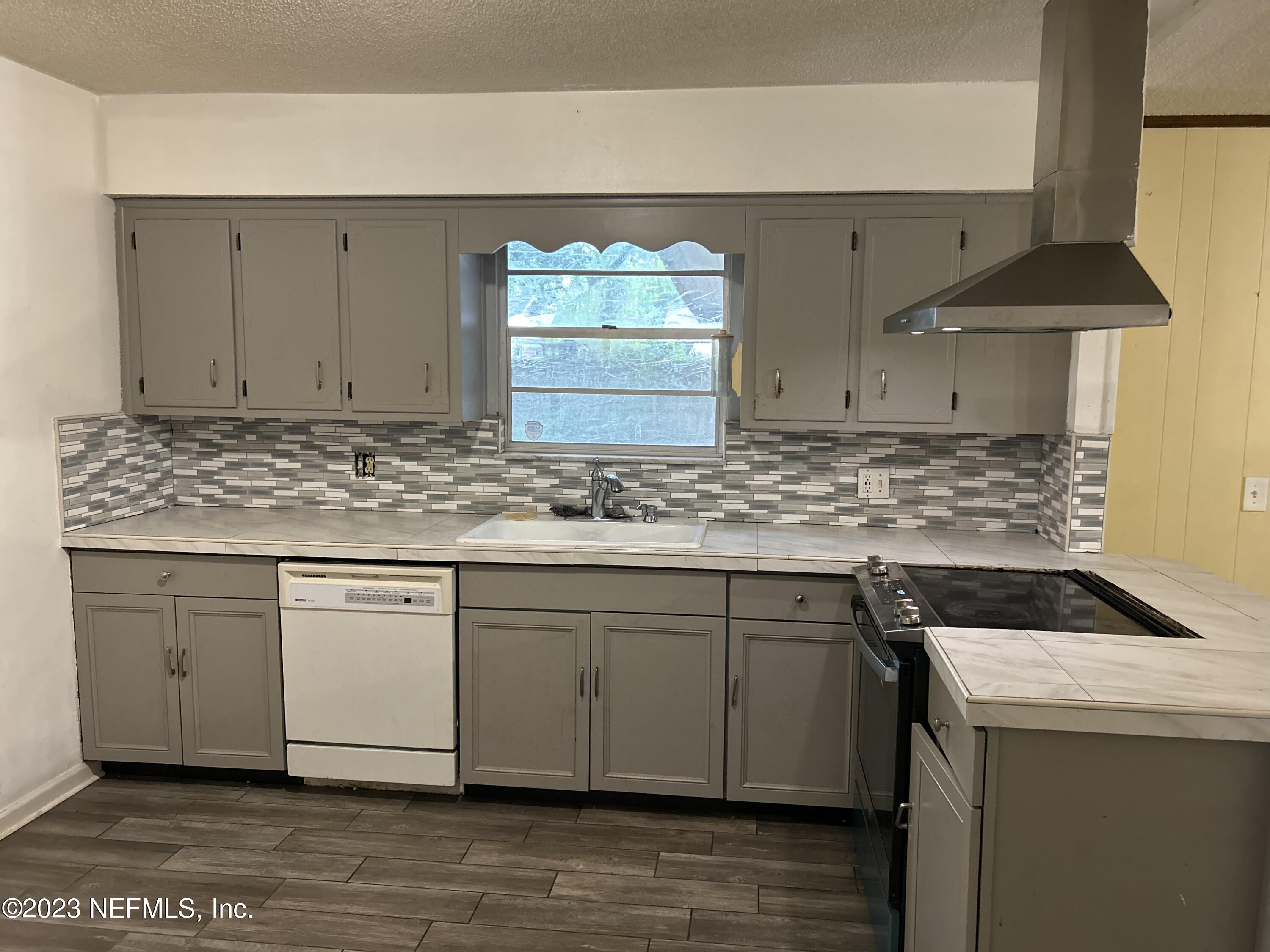 3733 Spring Lake Road Jacksonville, FL 32210 - Photo 4 of 7 a kitchen with stainless steel appliances granite countertop a sink stove and cabinets