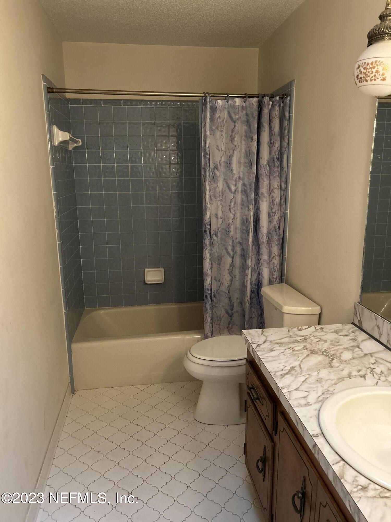 3733 Spring Lake Road Jacksonville, FL 32210 - Photo 5 of 7 a bathroom with a granite countertop bathtub sink vanity mirror and toilet