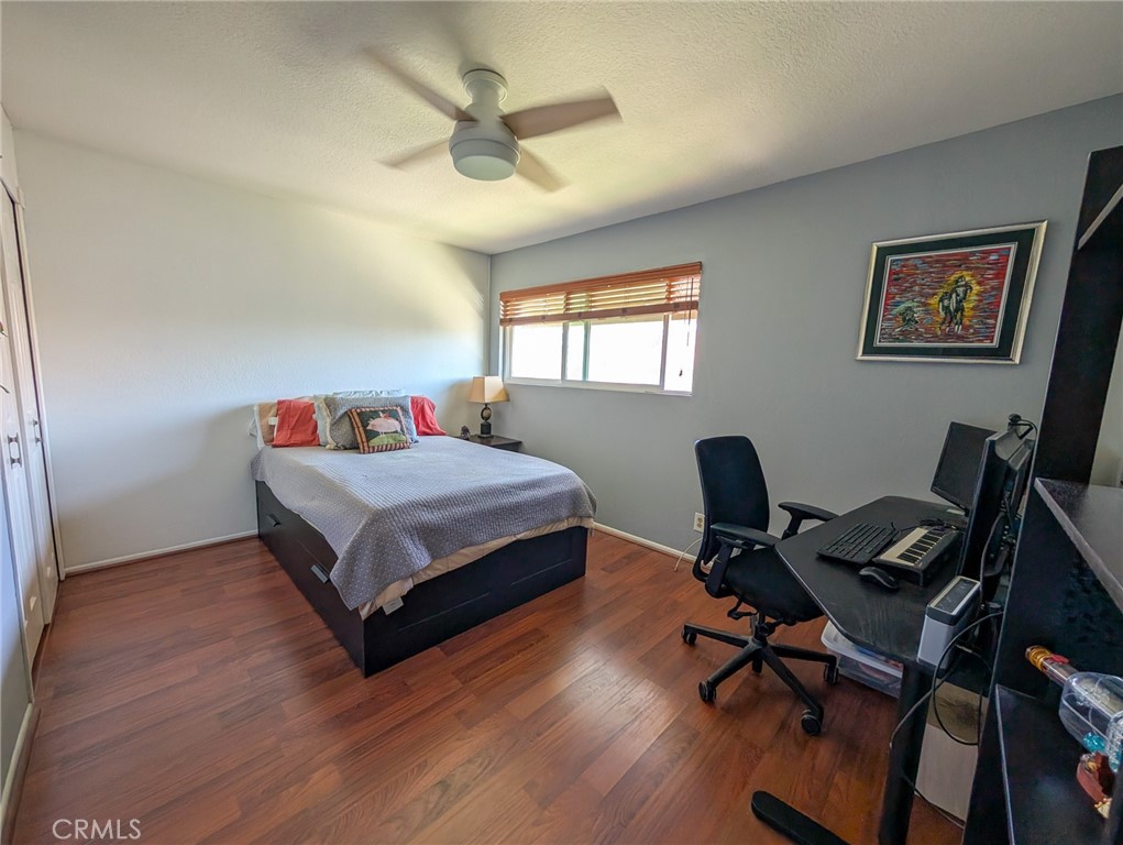 54 Oval Road, Unit 3 Irvine, CA 92604 - Photo 17 of 36 a bedroom with a bed a desk and chair with wooden floor