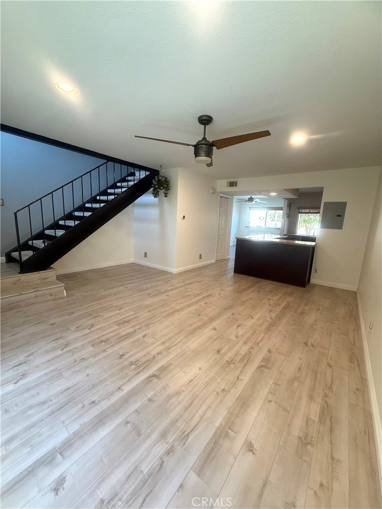 54 Oval Road, Unit 3 Irvine, CA 92604 - Photo 6 of 36 a view of an empty room with wooden floor and a ceiling fan