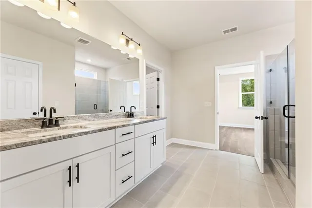 a spacious bathroom with a granite countertop sink mirror and shower
