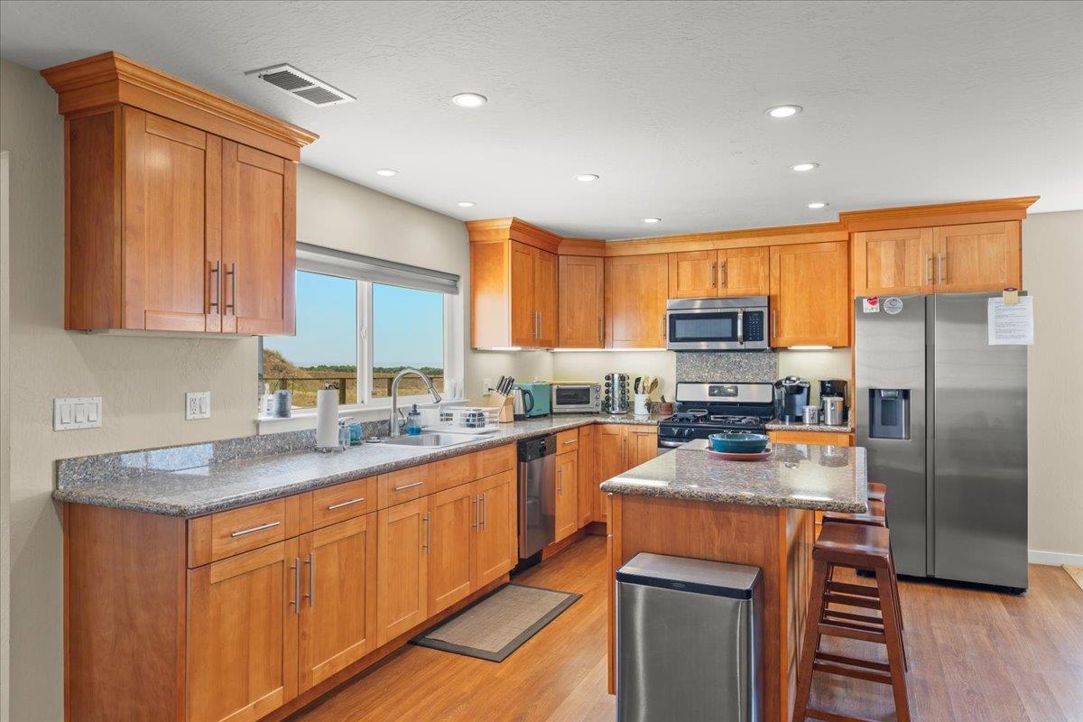 1263 Reservoir Road Pescadero, CA 94060 - Photo 61 of 75 a kitchen with stainless steel appliances granite countertop a refrigerator a stove top oven a sink and dishwasher