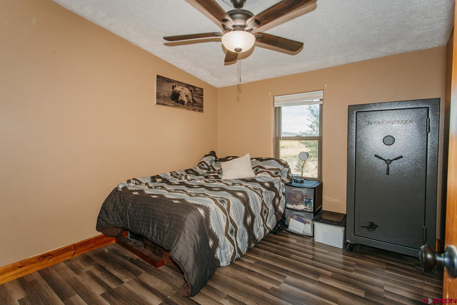5697 Peach Valley Road Delta, CO 81416 - Photo 13 of 31 a bedroom with a bed and a chandelier