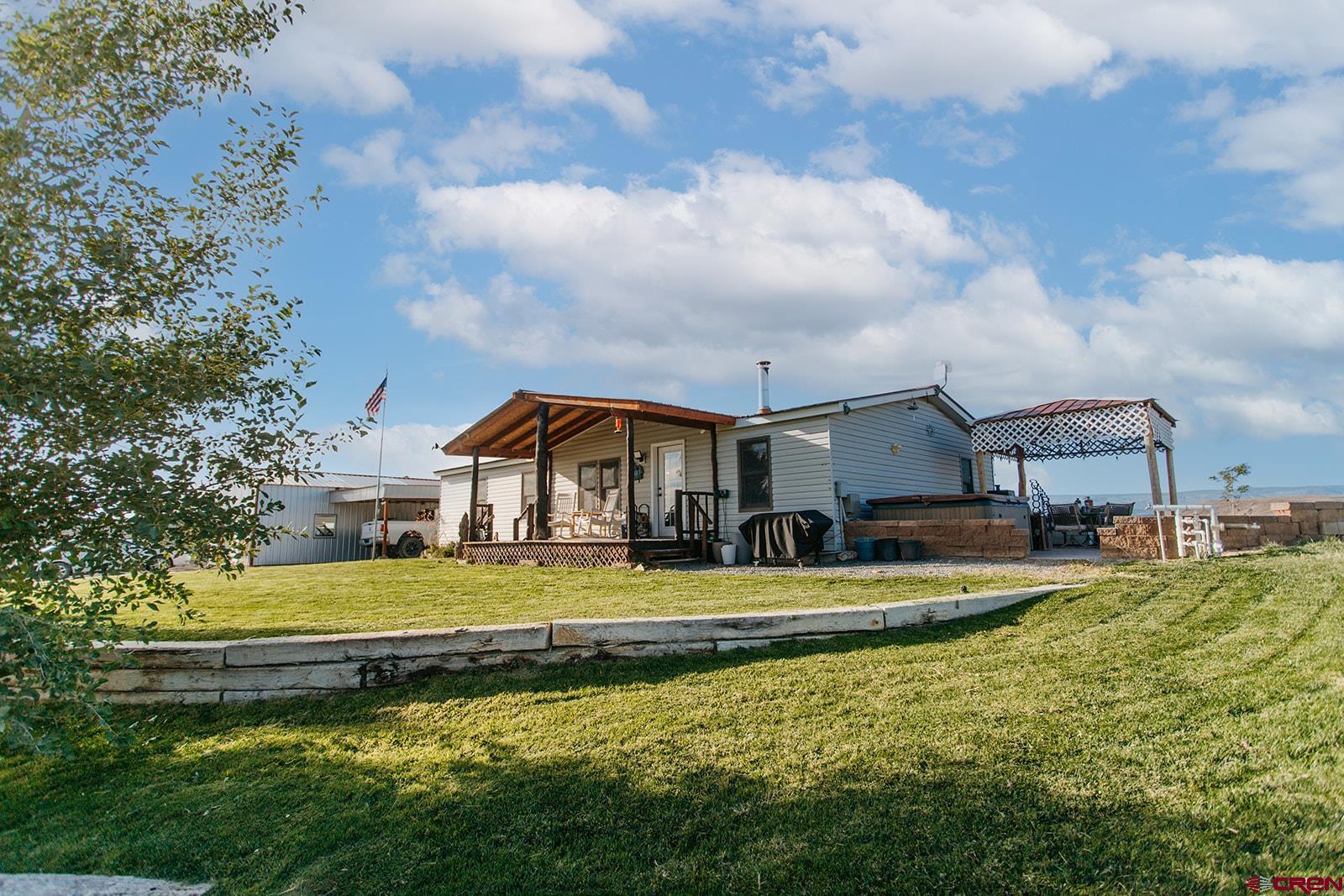 5697 Peach Valley Road Delta, CO 81416 - Photo 26 of 31 a view of a house with a big yard and large trees