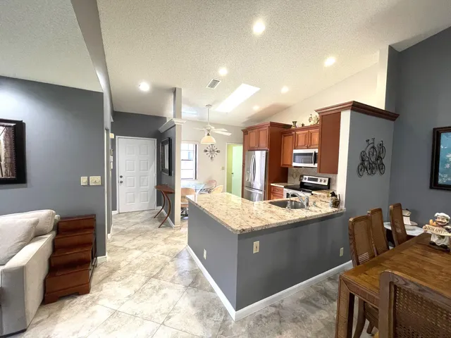 a large kitchen with kitchen island a sink stainless steel appliances and cabinets