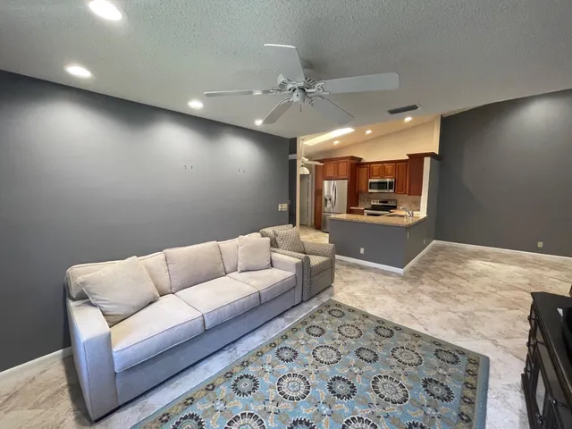 a large white kitchen with a sink and dishwasher a stove top oven with wooden floor