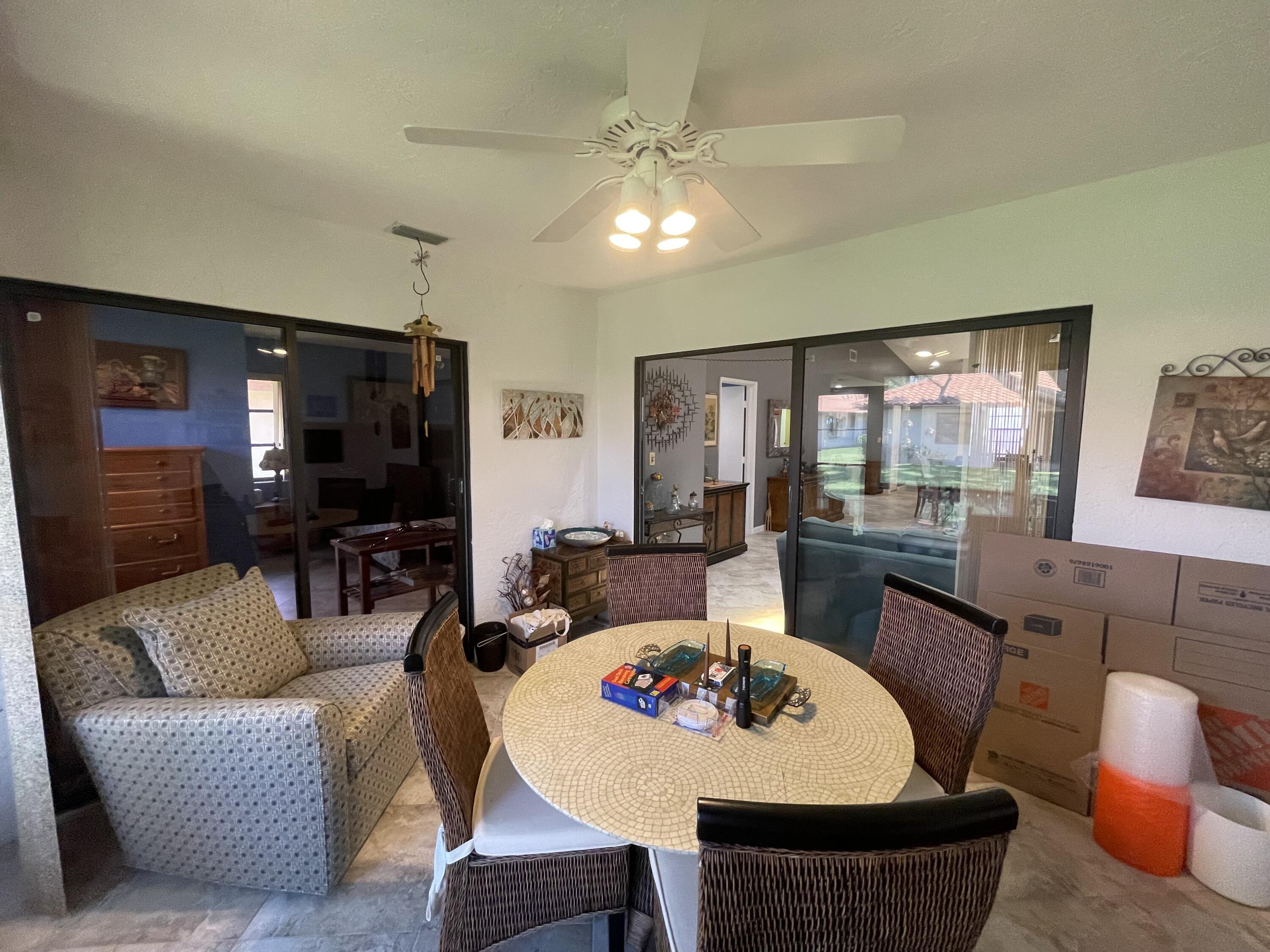 6141 Sunny Pointe Circle, Unit B Delray Beach, FL 33484 - Photo 30 of 62 a living room with furniture a flat screen tv and a large window