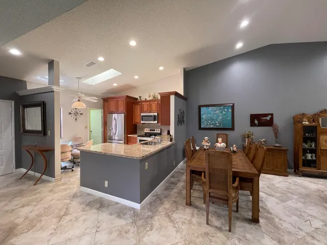 a large kitchen with cabinets table and chairs