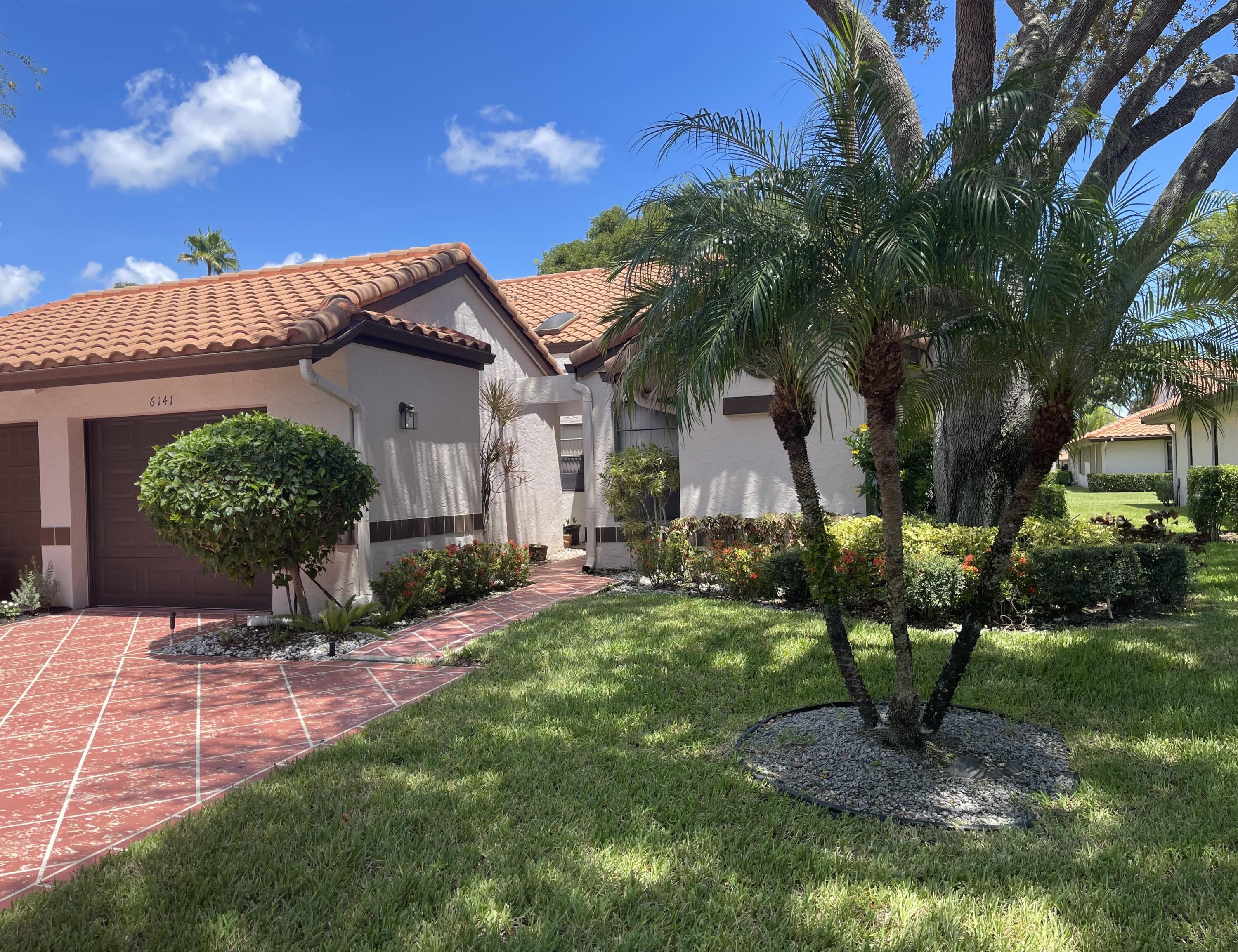 6141 Sunny Pointe Circle, Unit B Delray Beach, FL 33484 - Photo 56 of 62 a front view of a house with garden