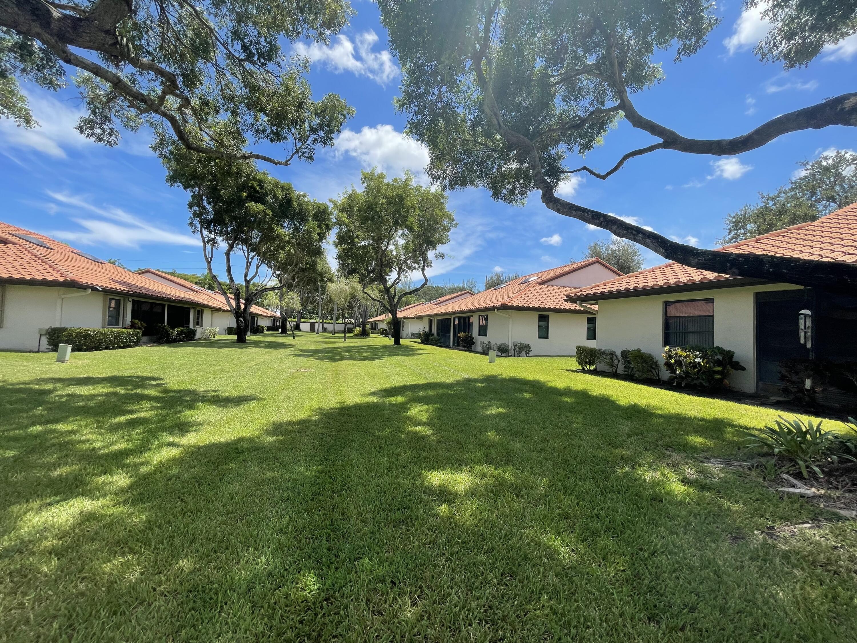 6141 Sunny Pointe Circle, Unit B Delray Beach, FL 33484 - Photo 61 of 62 a front view of a house with a garden