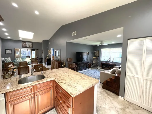 a large kitchen with kitchen island a large counter top appliances and cabinets