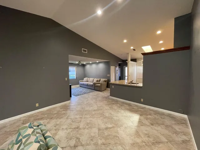 a spacious bedroom with a bed and a chandelier