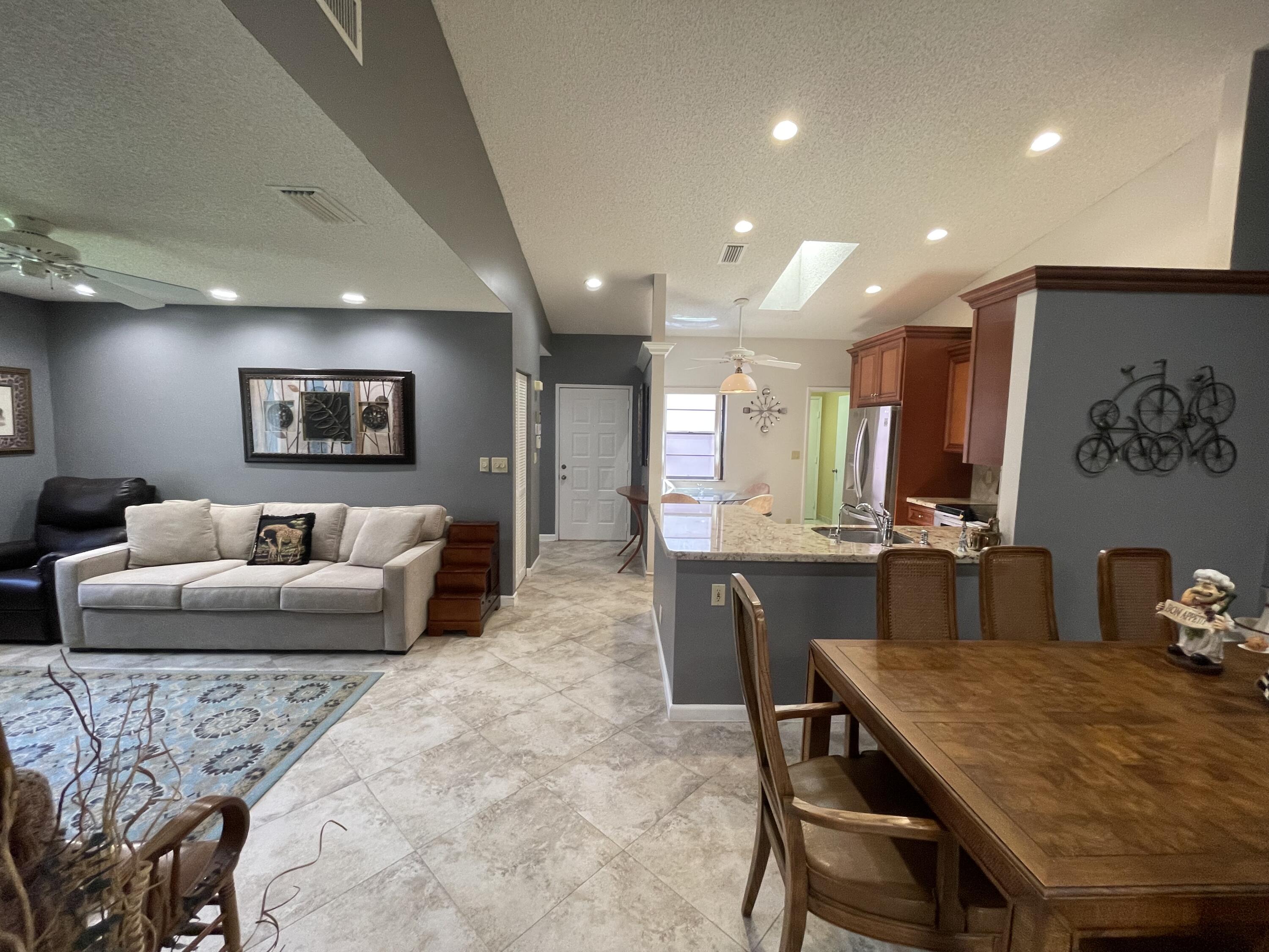 6141 Sunny Pointe Circle, Unit B Delray Beach, FL 33484 - Photo 10 of 62 a living room with furniture potted plant and kitchen view