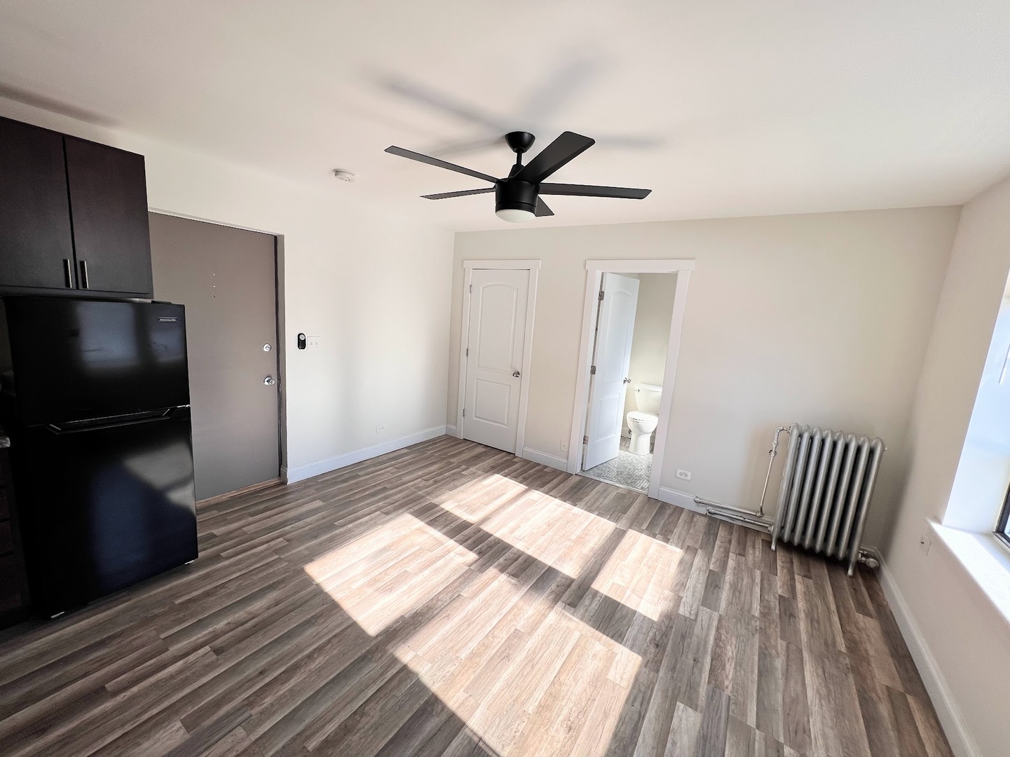 3933 North Clarendon Avenue, Unit 411 Chicago, IL 60613 - Photo 7 of 12 a view of empty room with wooden floor and fan
