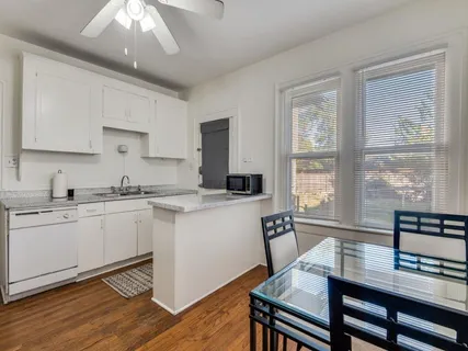 a kitchen with a table chairs sink and cabinets