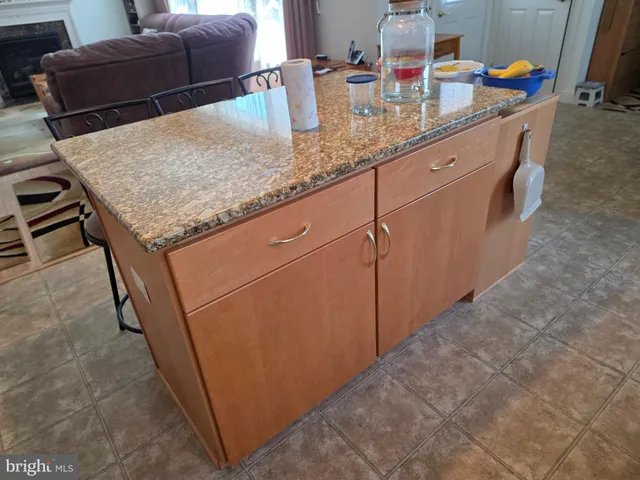 a kitchen with stainless steel appliances kitchen island granite countertop a sink dishwasher a stove a refrigerator a microwave oven with cabinets and wooden floor