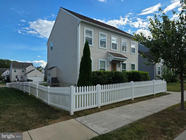 a view of a house with a small yard and wooden fence