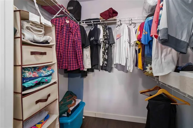 a view of walk in closet with clothes and shoes