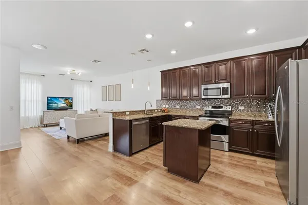 a kitchen with stainless steel appliances granite countertop a sink stove and refrigerator