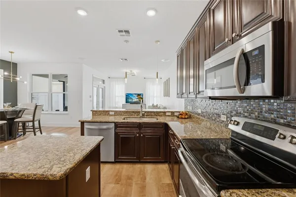 a kitchen with kitchen island granite countertop stainless steel appliances and a sink