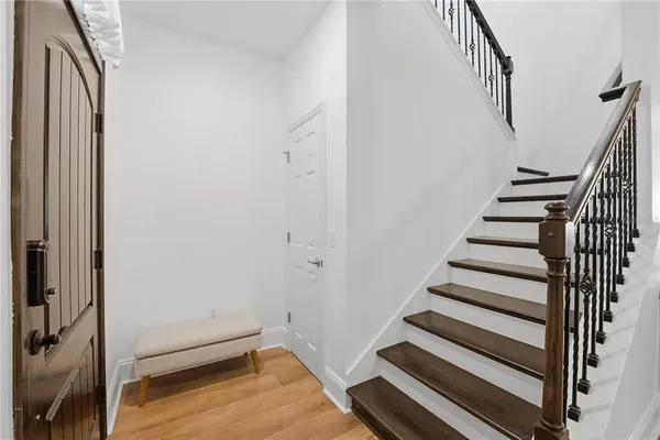a view of a hallway with wooden floor and chair