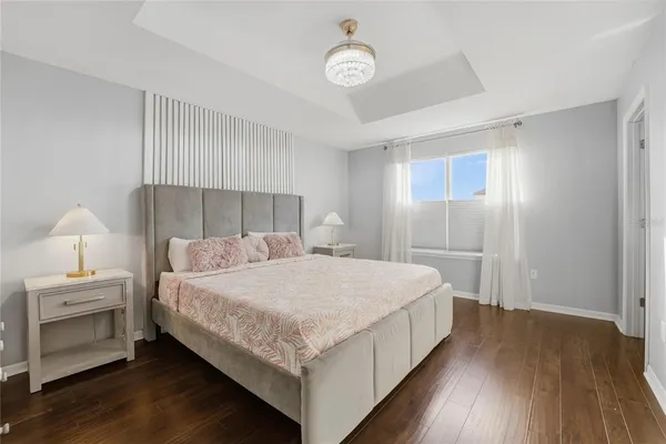 a bedroom with a bed and a table with wooden floor