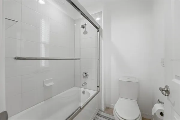 a view of a porch with chairs and floor to ceiling window and a yard