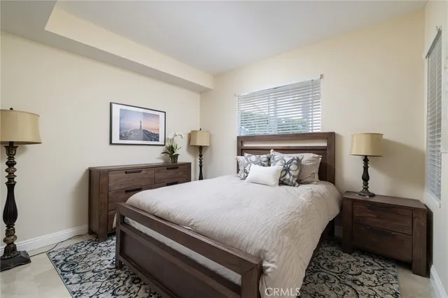 a bedroom with a bed and a lamp with the dresser