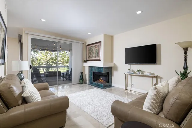 a living room with furniture a fireplace and a flat screen tv
