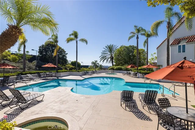 a view of a swimming pool with a patio and potted plants