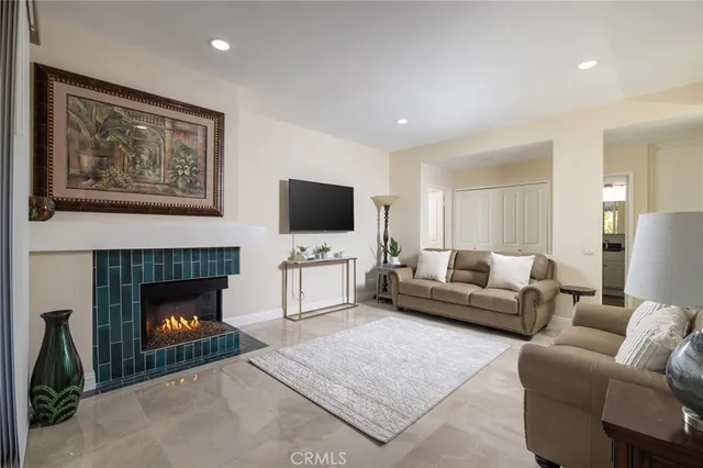 a living room with furniture a fireplace and a flat screen tv