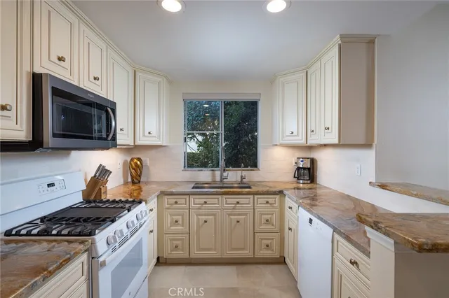 a kitchen with stainless steel appliances granite countertop white cabinets granite counter tops and a stove
