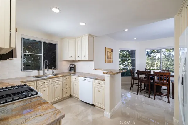 a kitchen with white cabinets and sink