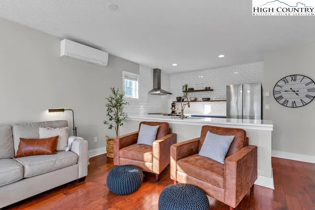 a living room with a fireplace a flat screen tv and a window