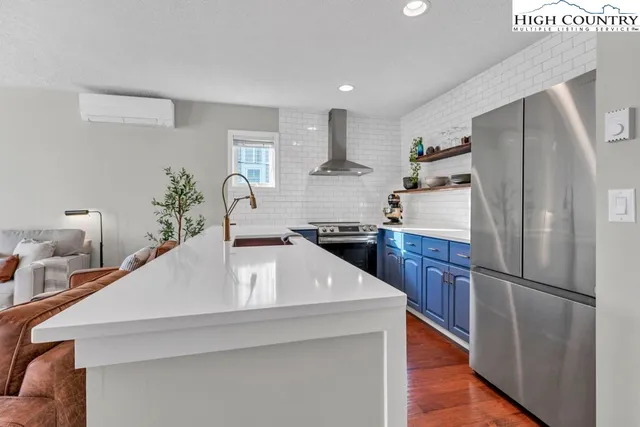 a kitchen with stainless steel appliances granite countertop a refrigerator and a stove