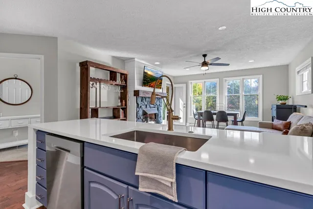 a living room with furniture kitchen view and a chandelier