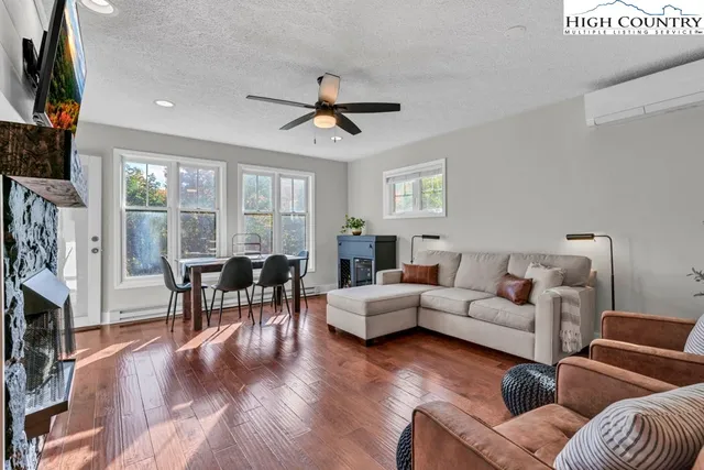 a living room with furniture kitchen view and a lamp