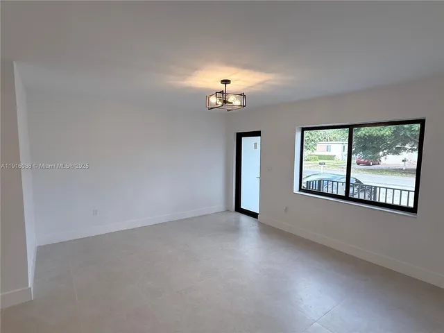 an empty room with windows and ceiling fan