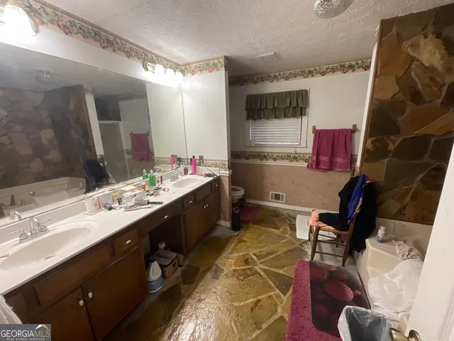 a bathroom with a double vanity sink mirror and shower