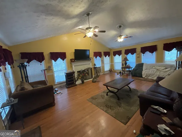 a living room with furniture gym equipment and a flat screen tv