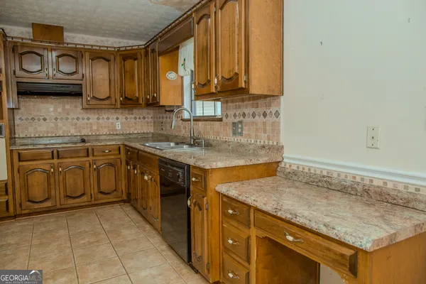 a view of an empty room with wooden floor and a fireplace