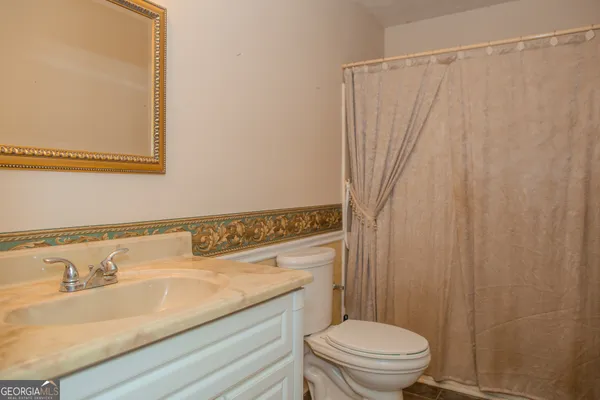 a backyard of a house with large trees and brick walls