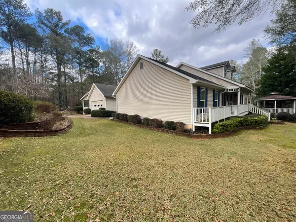 a front view of a house with a yard and trees