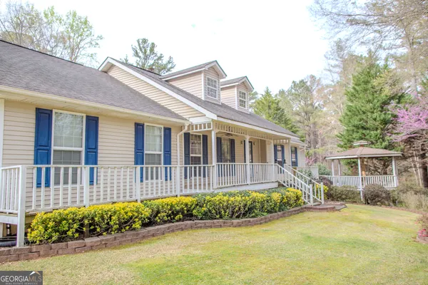 a view of a house with large windows and flower plants