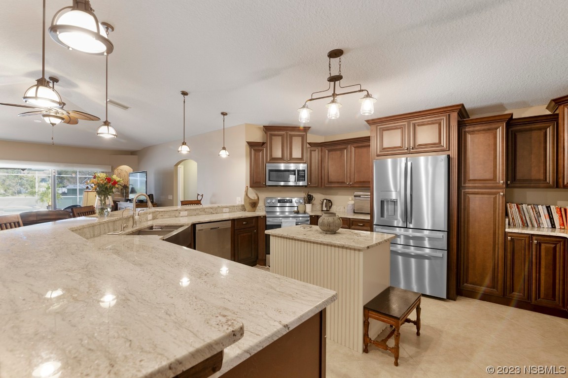 1815 Air Park Road Edgewater, FL 32132 - Photo 10 of 54 a kitchen with refrigerator and chairs