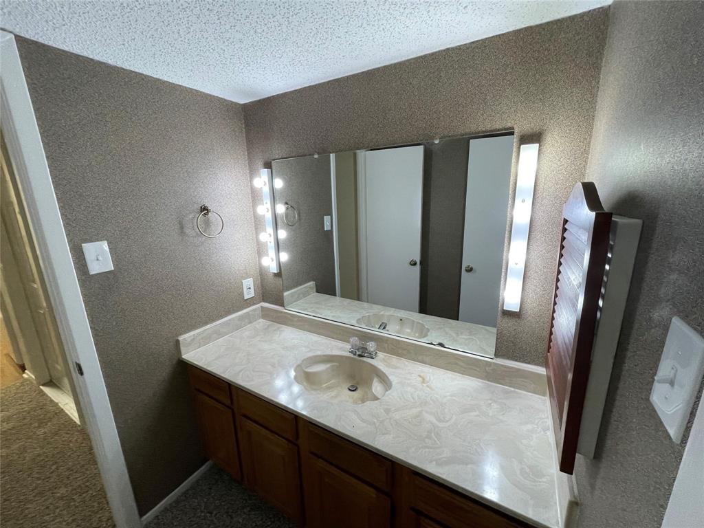 11480 Audelia Road, Unit 231 Dallas, TX 75243 - Photo 2 of 15 a bathroom with a granite countertop sink and a mirror