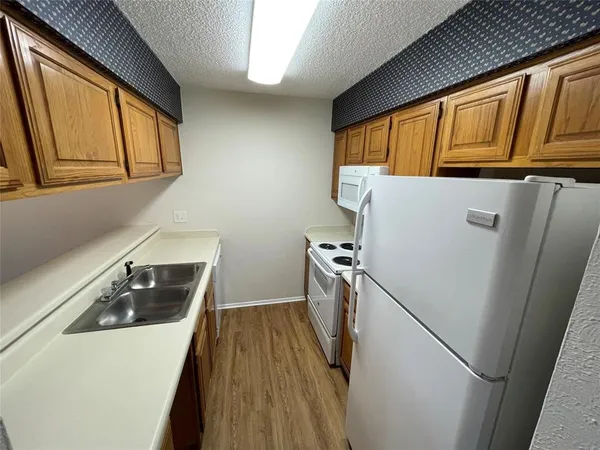 a kitchen with a refrigerator a stove and wooden cabinets